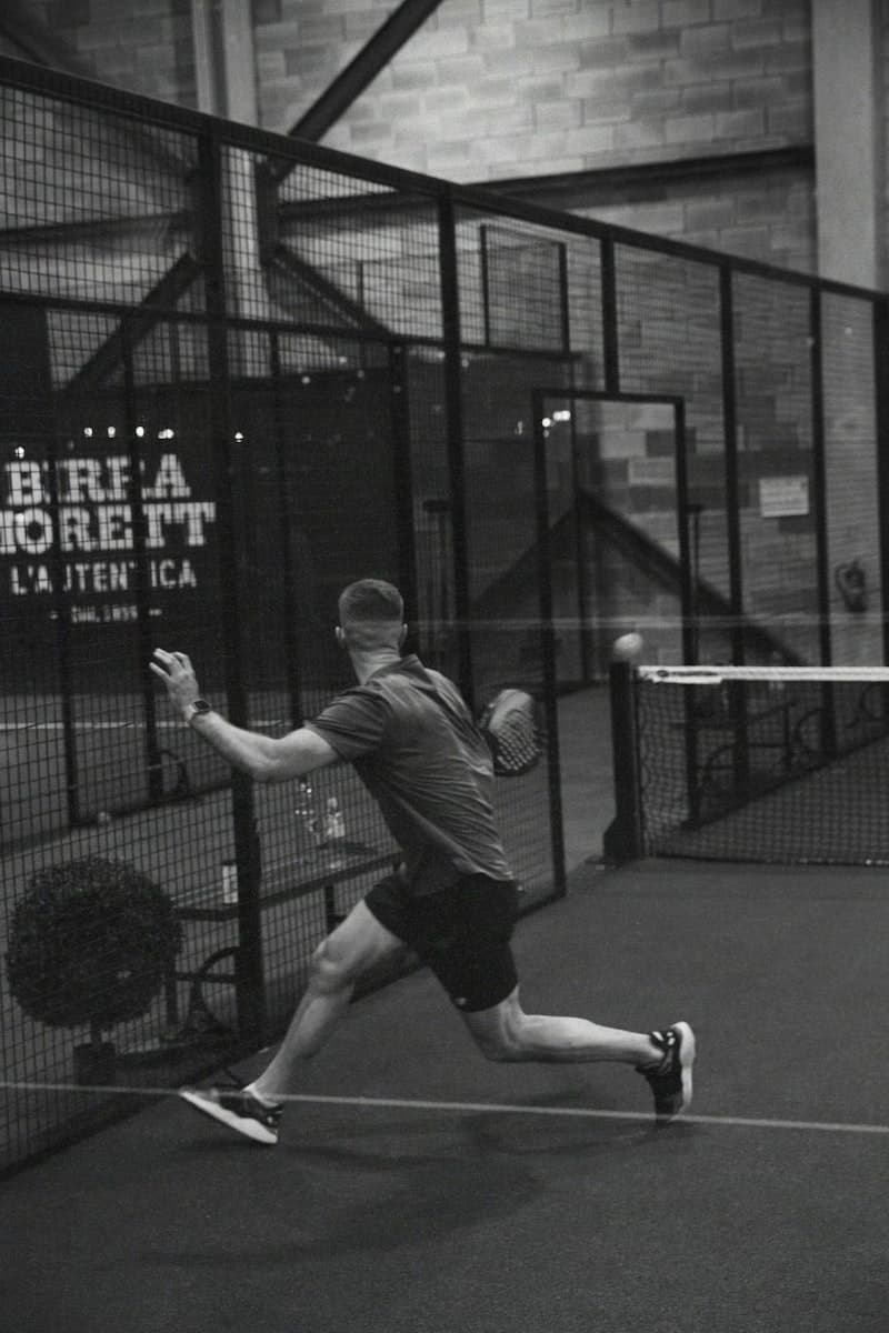 Padelspeler in actie op de baan